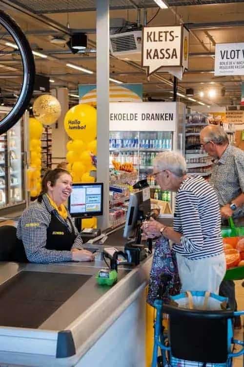 Femme âgée dans une caisse de magasin Jumbo