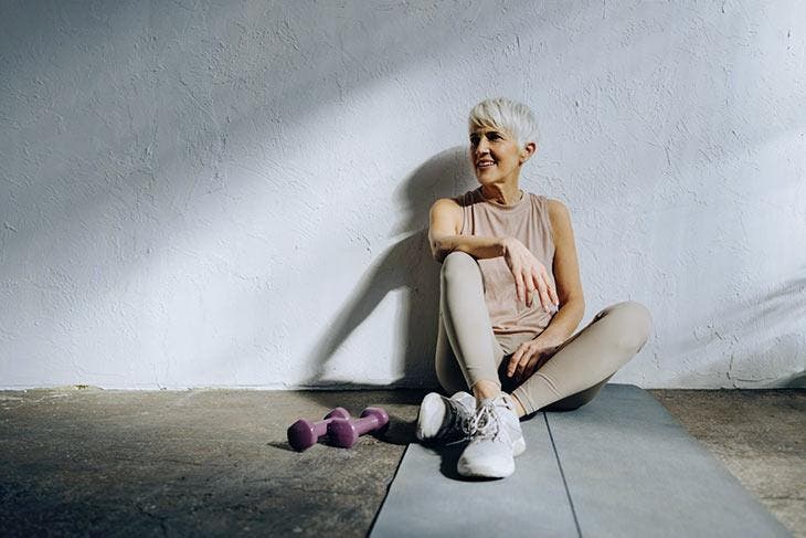 Femme âgée sur un tapis de Yoga