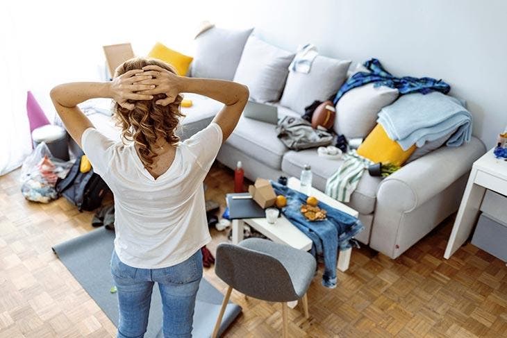 Femme face à une maison en désordre