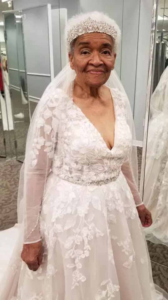 Martha Trucker enfilant une robe de mariée