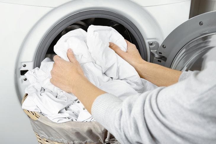 Mettre du linge blanc dans la machine à laver 