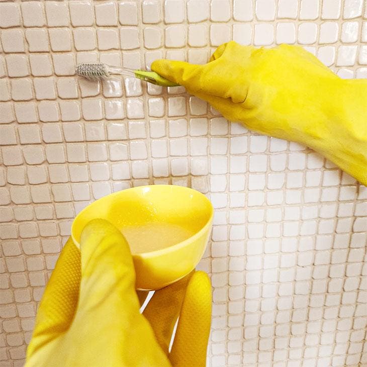 Nettoyer les joints de carrelage avec une brosse à dents et du bicarbonate