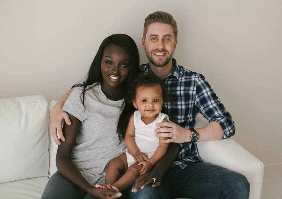 Nikki et Jamie Perkins avec leur fille Ava assis sur un fauteuil