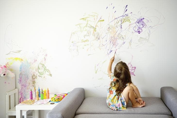 Petite fille qui dessine sur le mur