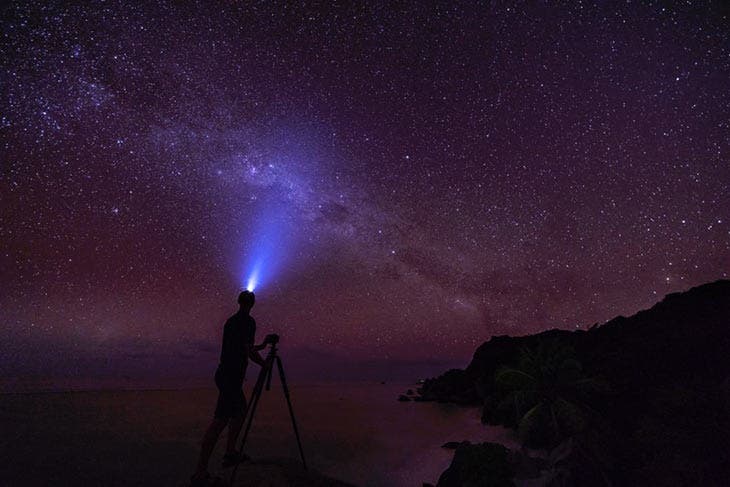 Photographe avec lampe frontale et trépied