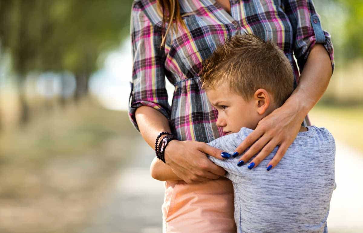 Un petit garçon sert sa maman dans le bras